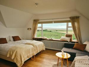 a bedroom with a bed and a window and a couch at Kjarnholt in Kjarnholt