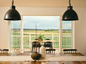 a dining room with a table and a large window at Kjarnholt in Kjarnholt