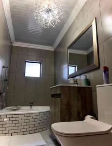 a bathroom with a bath tub and a chandelier at Kariebi Guest House in Bethlehem