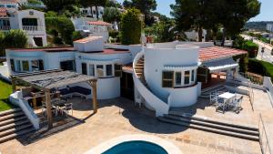 a large white house with a swimming pool in front of it at V206 Villa Isabel in Son Bou