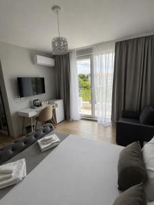 a living room with a couch and a table and a tv at Къща Грийн Хаус in Chernomorets