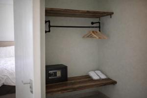 a room with a bed and a microwave on a shelf at Thyme Timeless Stay in Kamares