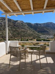 a patio with two chairs and a table with a view at Thyme Timeless Stay in Kamares +14 photos