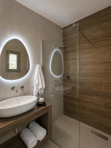 a bathroom with a sink and a glass shower at Thyme Timeless Stay in Kamares