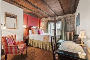a hotel room with a bed and a desk and a chair at Le Clos Saint-Louis - Par Aneyro in Quebec City