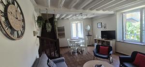 a living room with a large clock on the wall at Charmante Maison à Recloses in Recloses