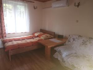 a bedroom with a bed and a table and a window at Noclegi ''U Wandy'' in Polańczyk