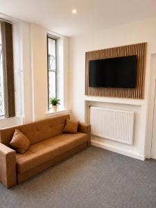 a living room with a couch and a flat screen tv at Snowdon Apartments in Stirling