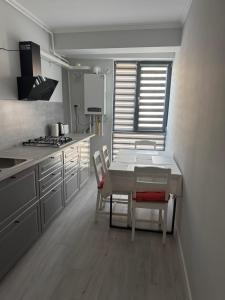 a kitchen with a table and chairs and a stove at Modern Apartment Constanța in Constanţa