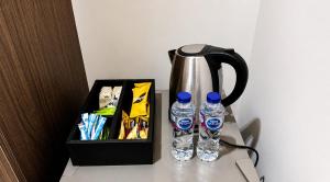 two bottles of water sitting next to a tea kettle at OrbitNet - Anwarat in Medina