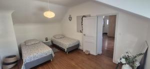 a small room with two beds and a door at Charmante Maison à Recloses in Recloses