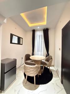 a dining room with a table and some chairs at The Palm Luxe Apartment in Calabar