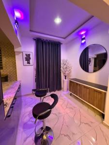 a purple room with two chairs and a mirror at The Palm Luxe Apartment in Calabar