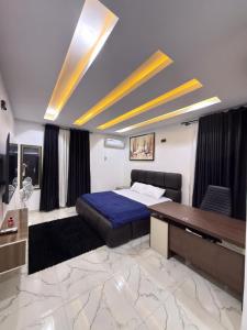 a bedroom with a bed and a desk in it at The Palm Luxe Apartment in Calabar