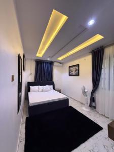 a bedroom with a large white bed with a black blanket at The Palm Luxe Apartment in Calabar