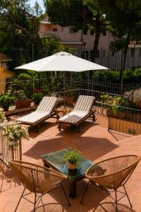 a patio with two chairs and a table and an umbrella at Officine Bordighera in Bordighera