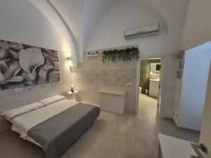 a bedroom with a bed and a painting on the wall at Zia Nennè Holiday Rooms in Monopoli
