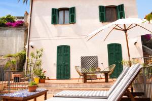 a patio with a table and an umbrella at Officine Bordighera in Bordighera