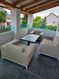 a patio with two couches and a table and chairs at Random Villa in Révfülöp