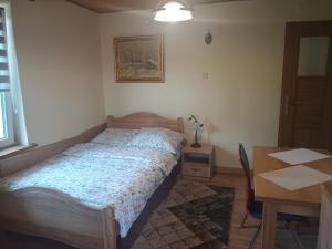 a bedroom with a bed and a table and a table and a tableablish at Noclegi ''U Wandy'' in Polańczyk