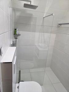 a white bathroom with a shower and a toilet at Random Villa in Révfülöp +9 photos