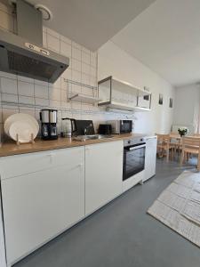 a kitchen with white cabinets and a stove top oven at Kyyveden Kartano Horsma 14 in Mikkeli +36 photos