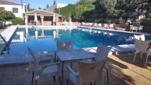 a patio with a table and chairs next to a swimming pool at Las Parras in Rute