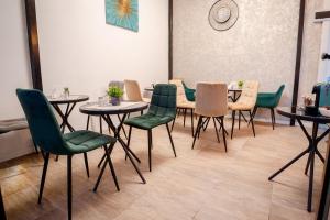 a dining room with tables and green chairs at Luna Boutique in Bucharest