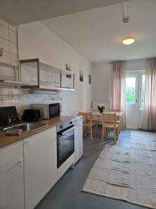 a kitchen with white cabinets and a dining room at Kyyveden Kartano Horsma 14 in Mikkeli