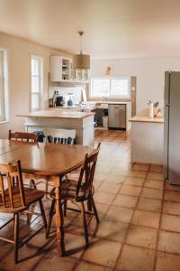 a kitchen with a wooden table and chairs in a room at Auberge du Jardin in Petit-Saguenay