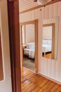 a room with two mirrors and a bedroom with a bed at Auberge du Jardin in Petit-Saguenay +87 photos