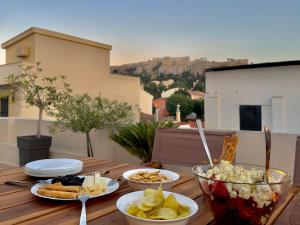a wooden table topped with plates and bowls of food at Theasis Athens in Athens