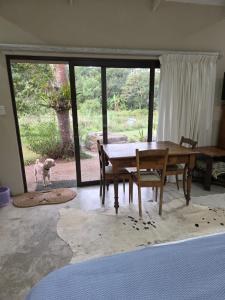 a dining room with a table and a dog looking out the window at Haines Haven in Albinia