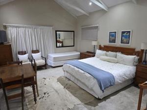 a bedroom with a bed and a table and a desk at Haines Haven in Albinia