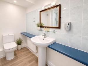 a bathroom with a sink and a toilet and a mirror at Wool Merchant Hotel HALIFAX in Halifax +46 photos