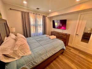 a bedroom with a large bed and a flat screen tv at The Chic Suite - 1BR with Luxe Amenities in Paterson