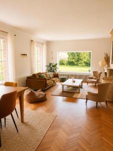 a living room with a couch and a table at Les jardins de Beaumont in Hem