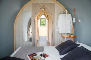 a bedroom with a bed and an arched doorway at Camping le Rural- 3 étoiles in Tibiran-Jaunac +36 photos