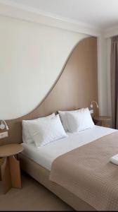ein Schlafzimmer mit einem großen Bett und weißen Kissen in der Unterkunft Bay View Hotel in Himarë