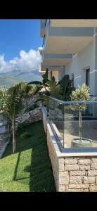 ein Haus mit Balkon und einer Palme in der Unterkunft Bay View Hotel in Himarë