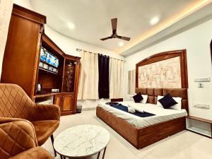 ein Schlafzimmer mit einem Bett, einer Couch und einem Fernseher in der Unterkunft Hotel Royal Corner - 500 Meters Near Golden Temple in Amritsar + 59 Fotos