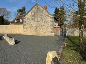 a stone building with rocks on the side of a road at Évasion champêtre in Ambillou +5 photos