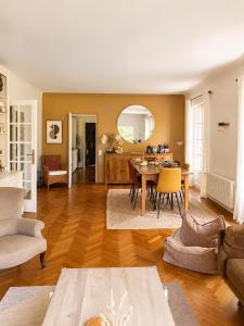 a living room with a table and a dining room at Les jardins de Beaumont in Hem