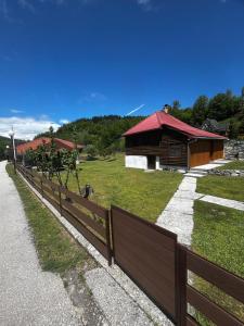 a fence in front of a house with a building at Apartmani LUX in Kolašin