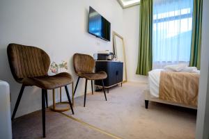 a bedroom with two chairs next to a bed at Luna Boutique in Bucharest