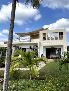 a building with a palm tree in front of it at Villa in Vipingo in Vipingo