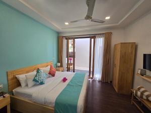 a bedroom with a large bed with blue walls at Dhiffushi Reef & Beach in Dhiffushi