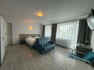 a bedroom with a bed and a couch and a chair at Marinas Rewa in Rewa