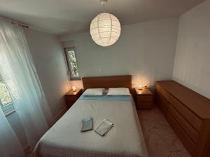 a bedroom with a bed with two books on it at Marija in Pakoštane