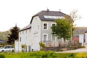 Casa blanca con paneles solares en el techo en Haus & Hof Guest House en Perl